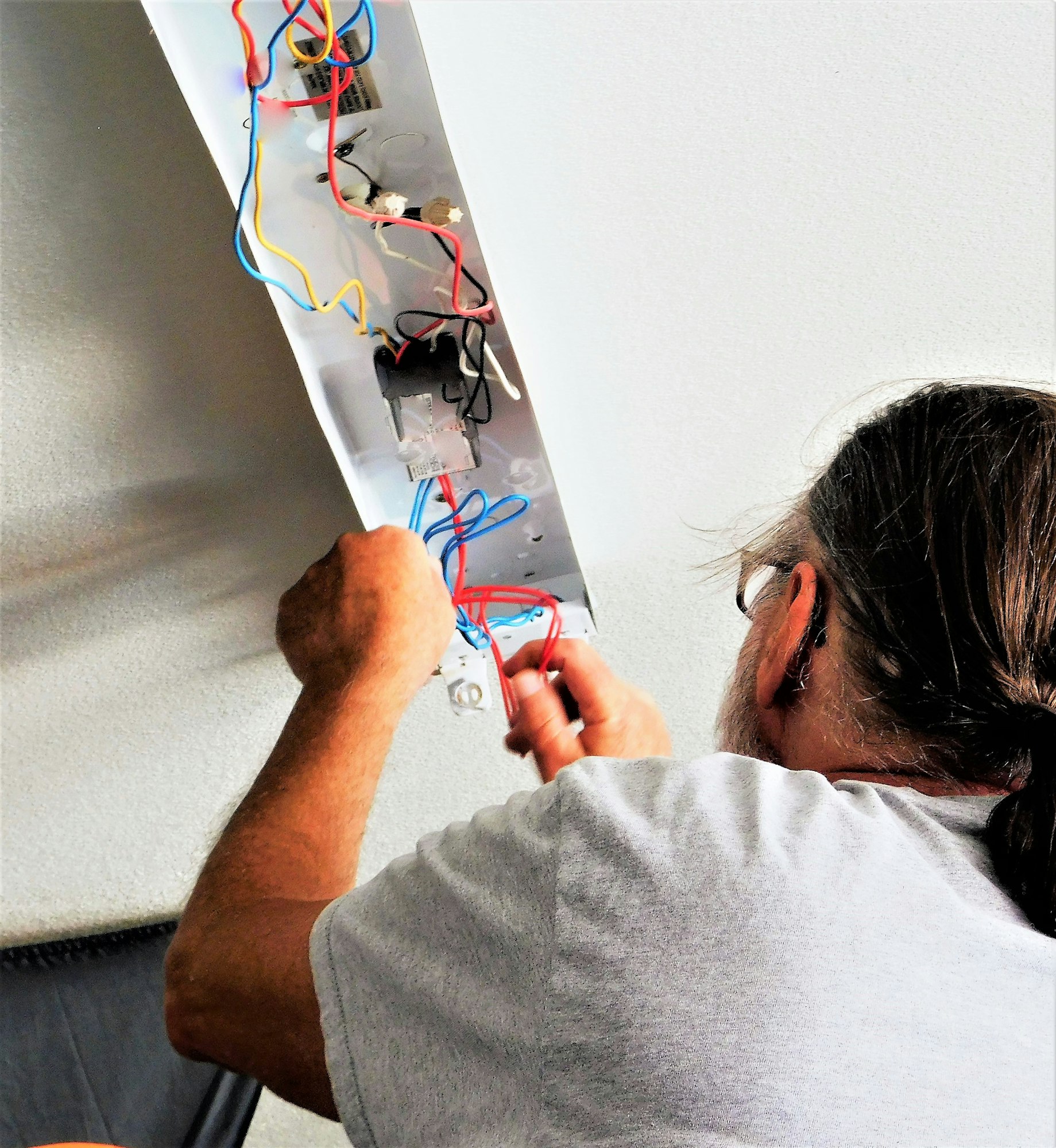 Electrician! Man On a Ladder Doing Electrical Wiring of Ceiling Lights! From Behind!